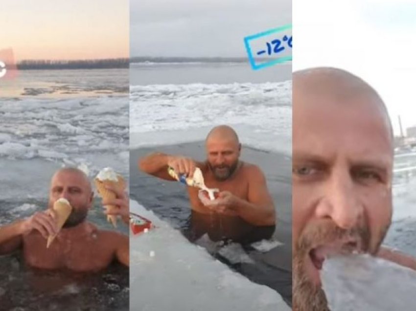 Burri rus që bën not në liqe të ngrirë, duke ngrënë akullore dhe akull nga uji