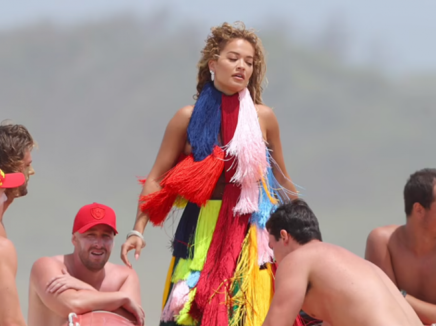 Rita Ora me veshje shumëngjyrëshe, e rrethuar me meshkuj gjysmë të zhveshur në Australi